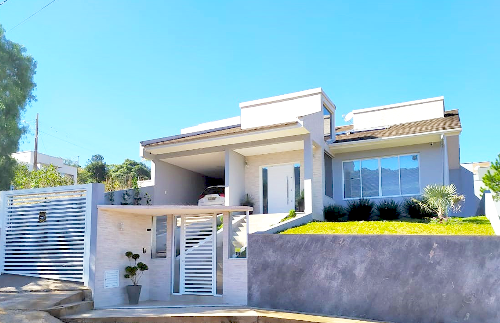 Fachada contemporânea com guarda-corpo em alumínio polido e grandes panos de vidro